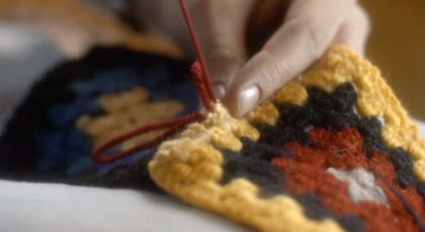 Screenshot of person sewing blanket squares