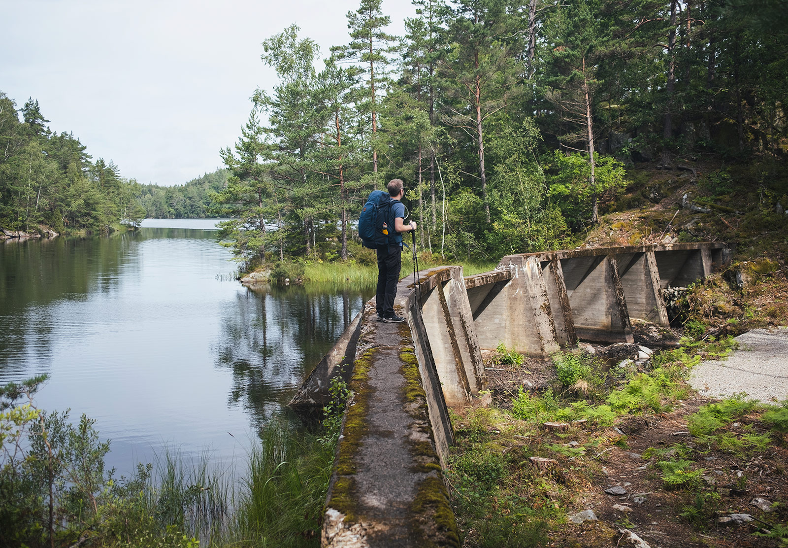 Man standing on small concrete dam