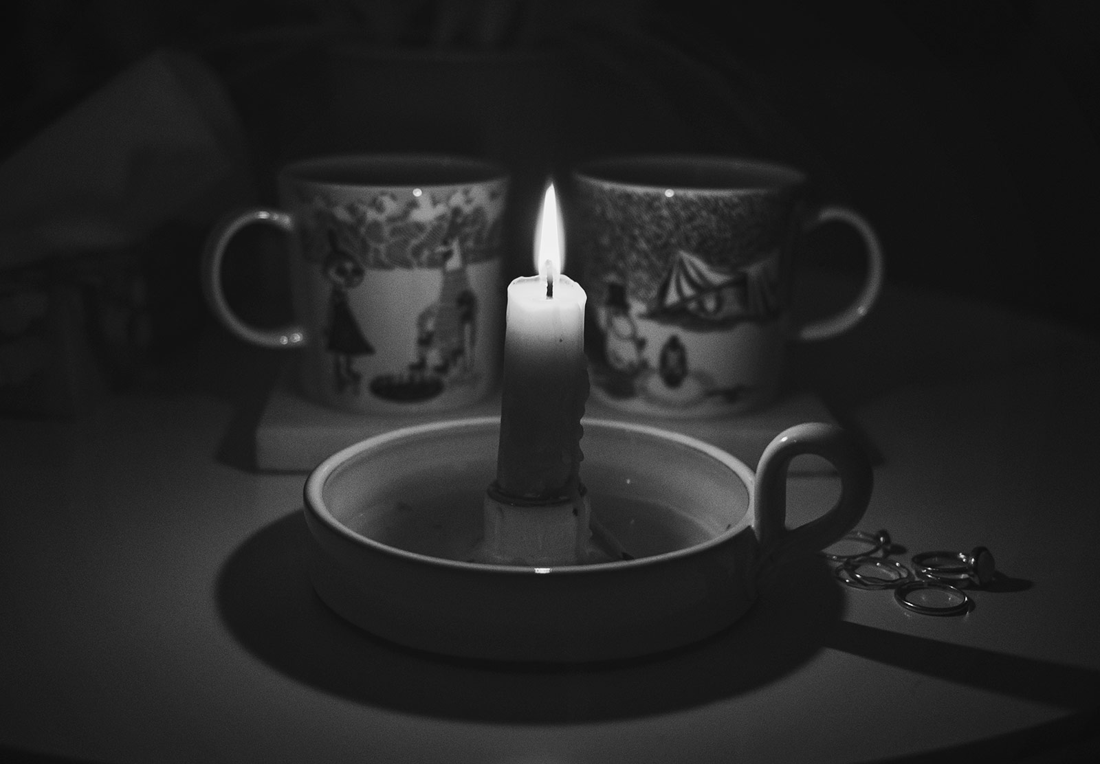 Candle in front of mugs