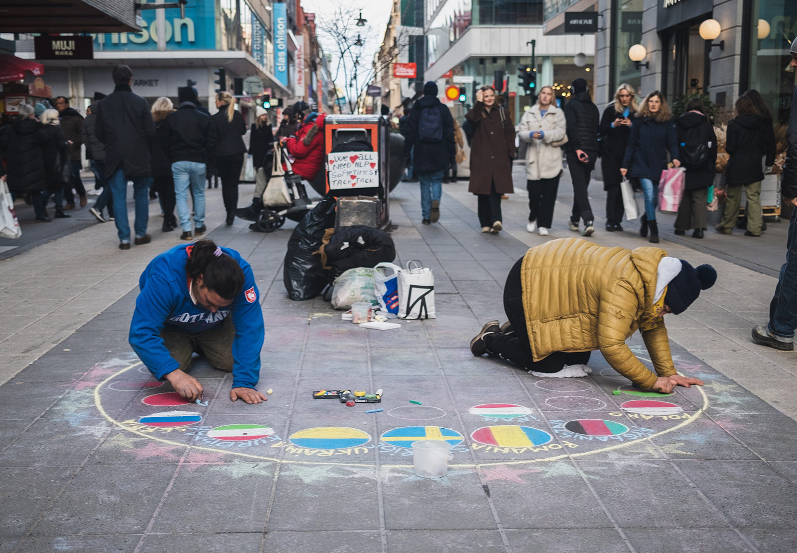 Men drawing with chalk on pavement