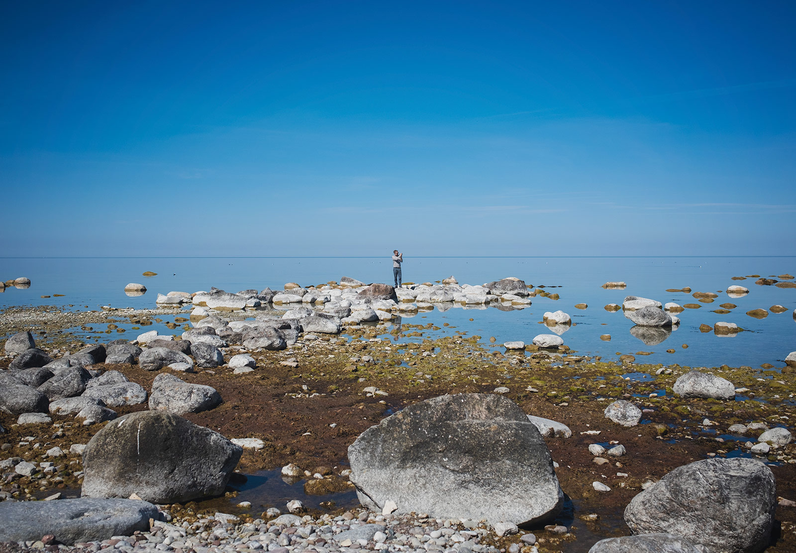 Man stood on rocks in the sea