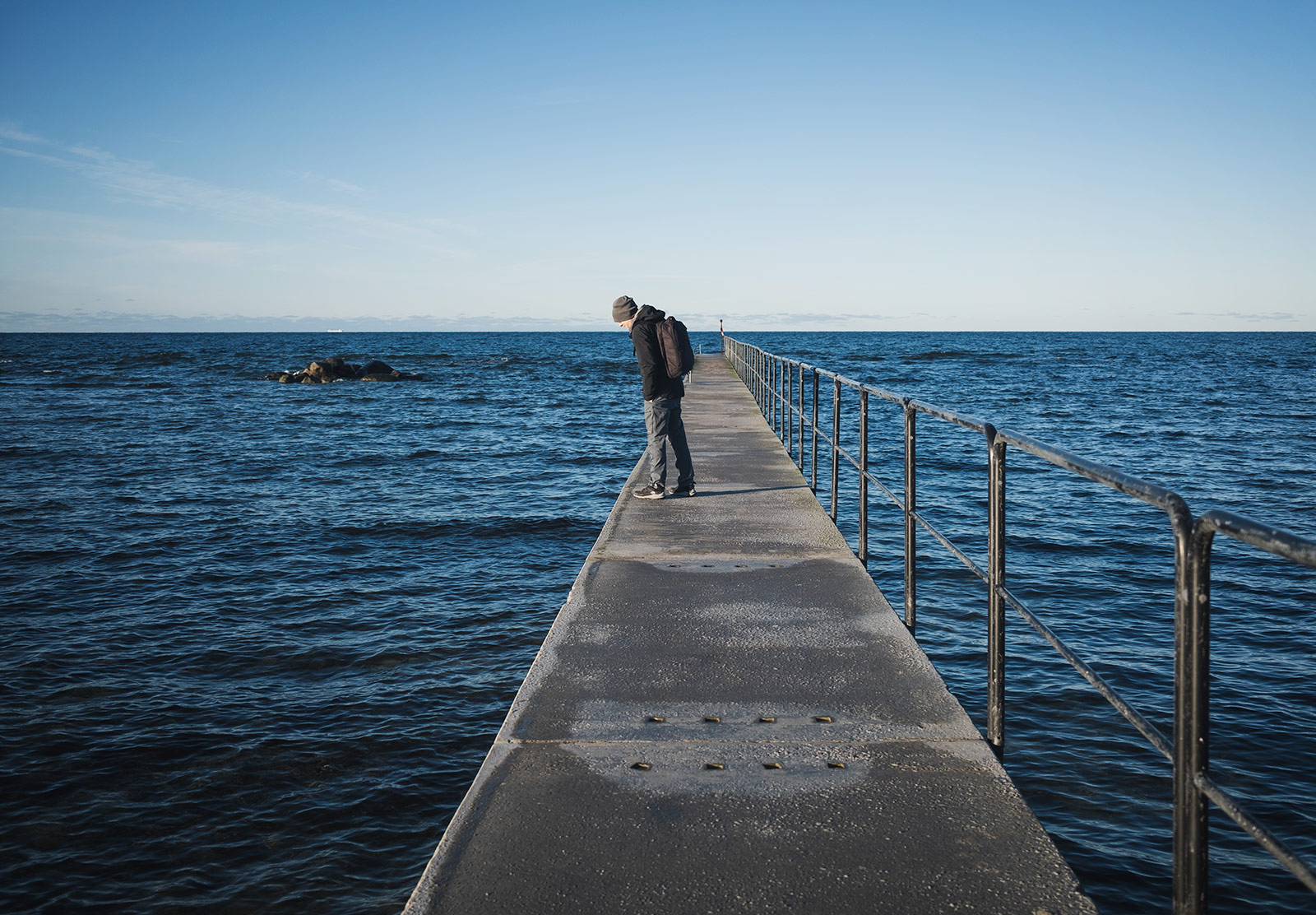 Man standing on sea jetty
