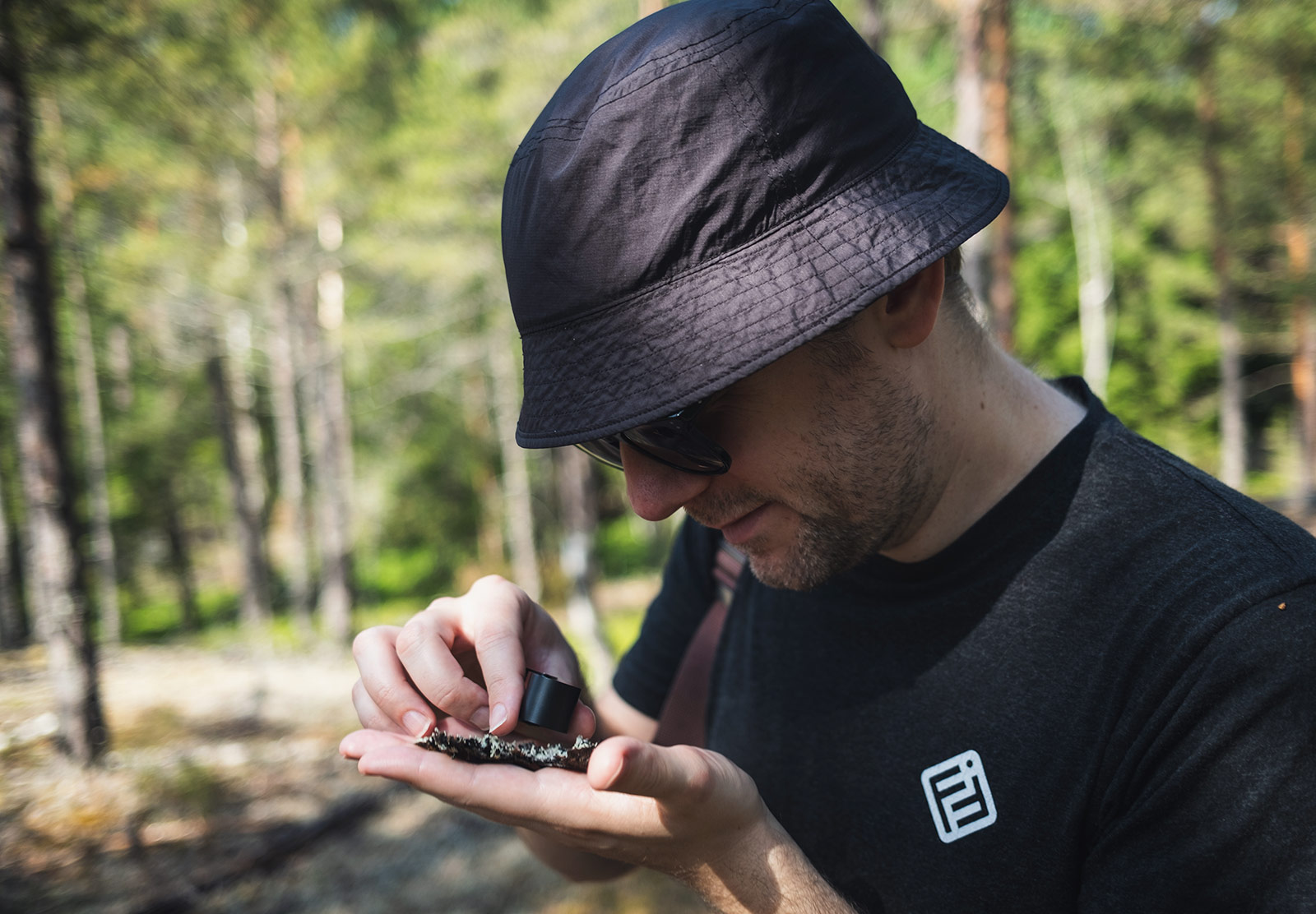Man examining lichen with hand lens