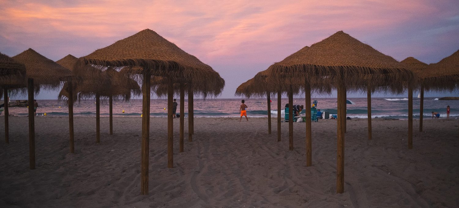 Umbrellas on a beach at sunset