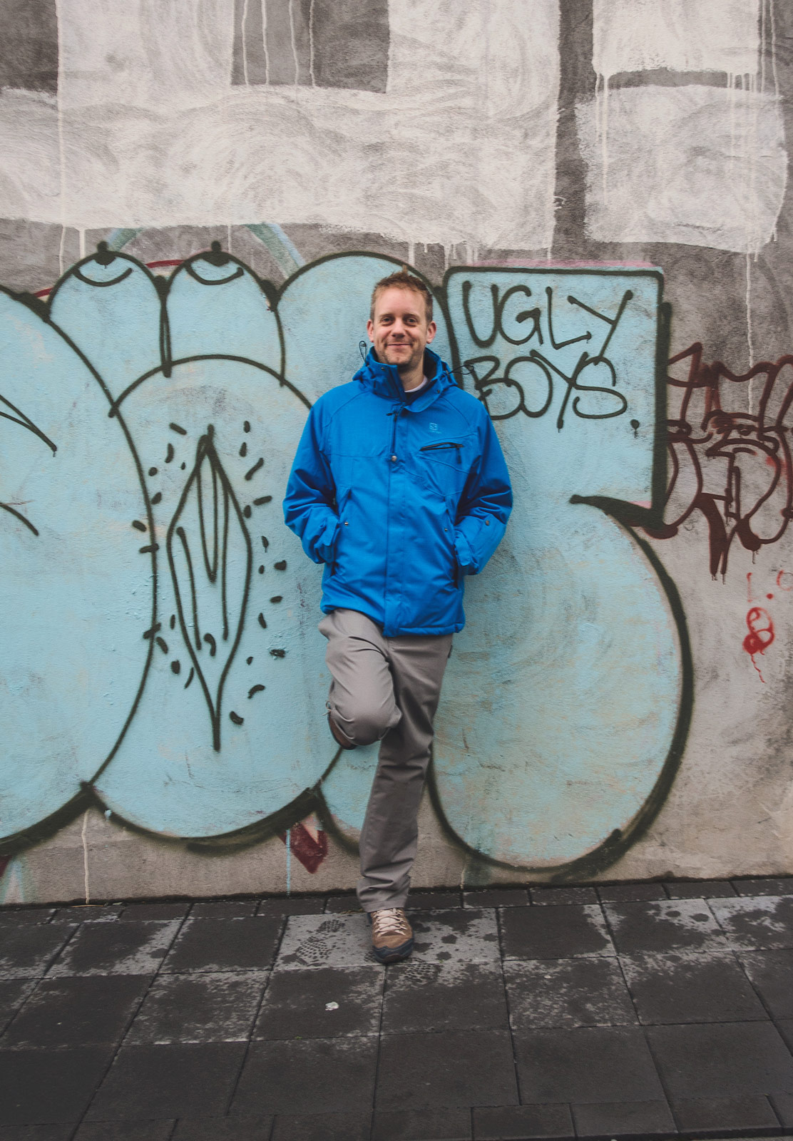 Man leaning on graffiti wall