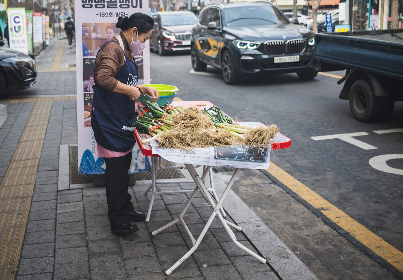 Woman cutting onions on table in the street