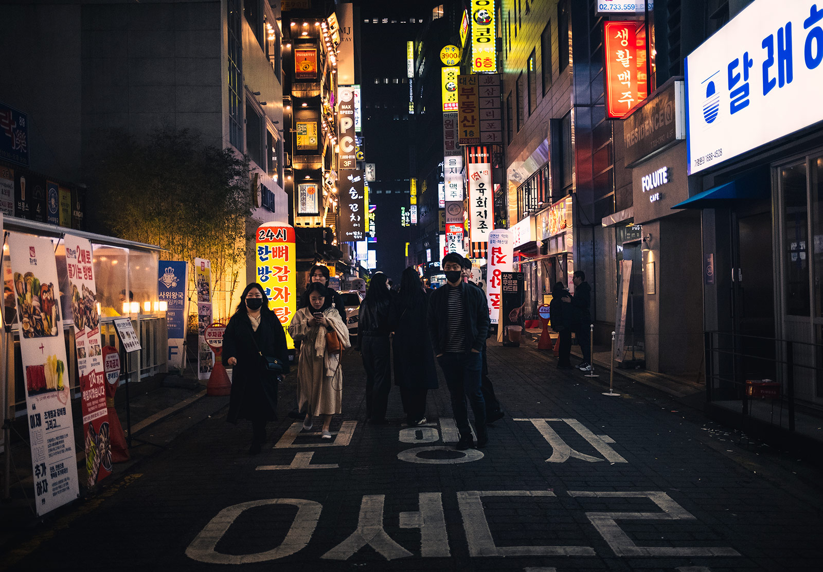 People walking down street at night