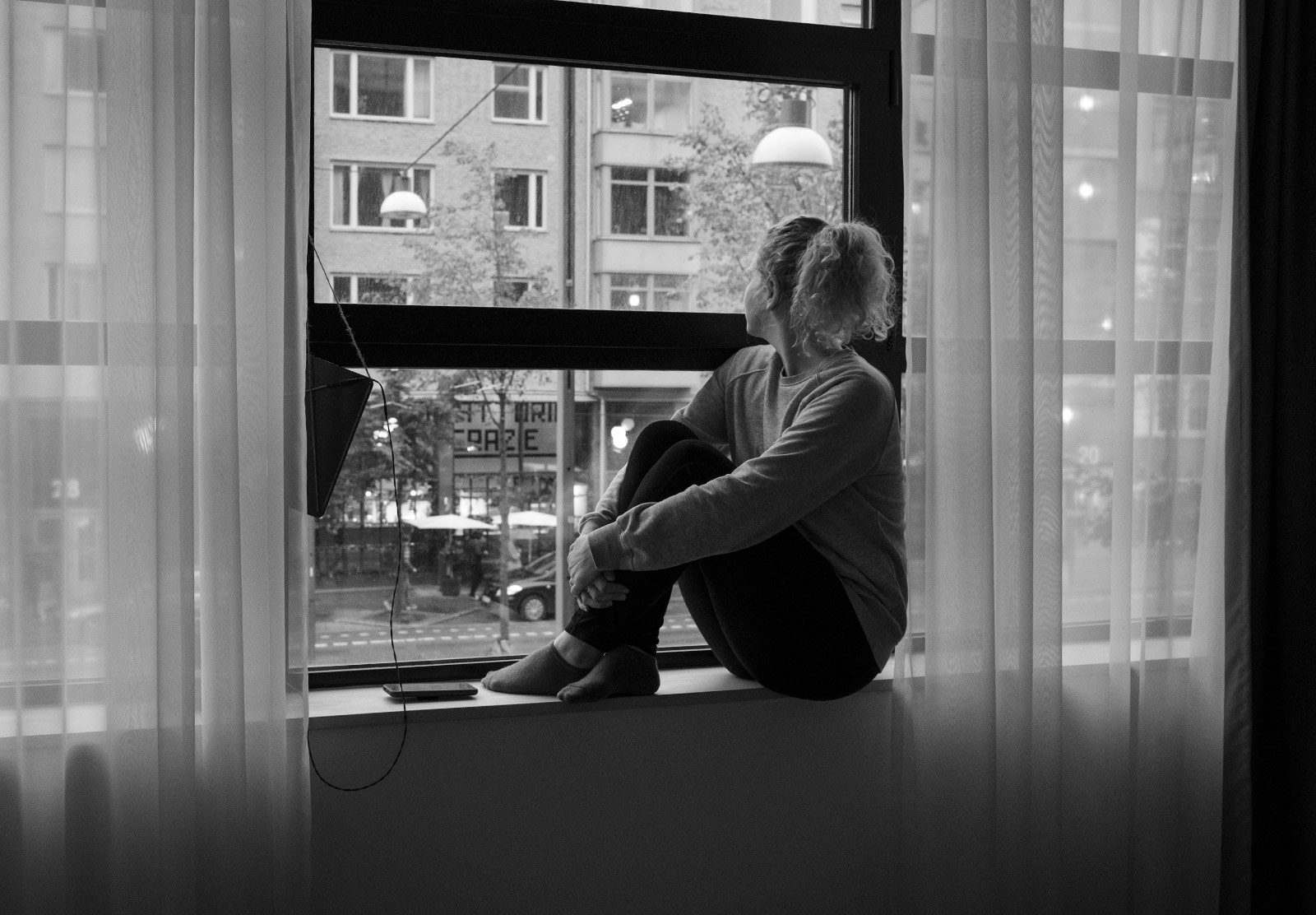 Woman sitting on windowsill