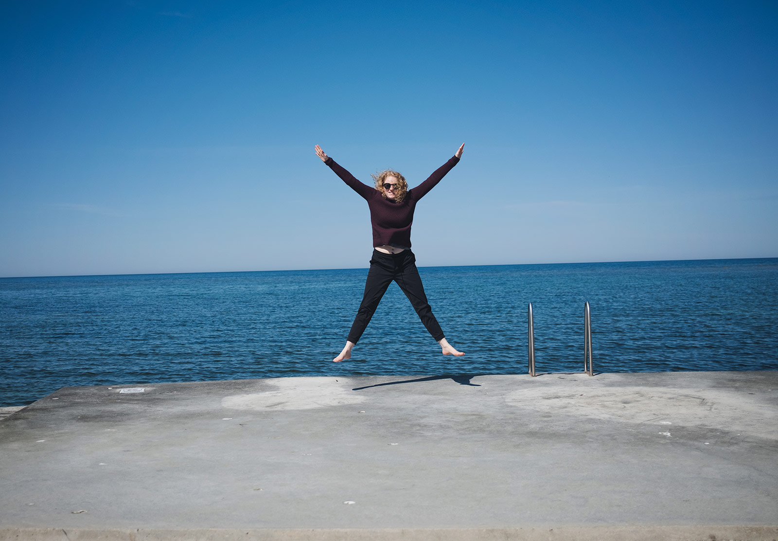 Woman jumping next to sea