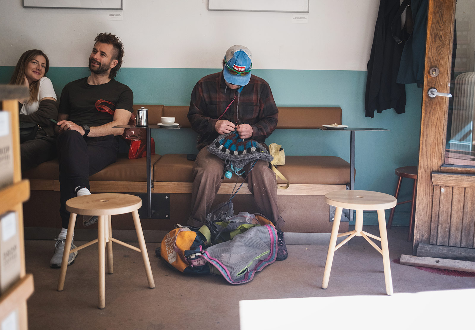 Man knitting in a café