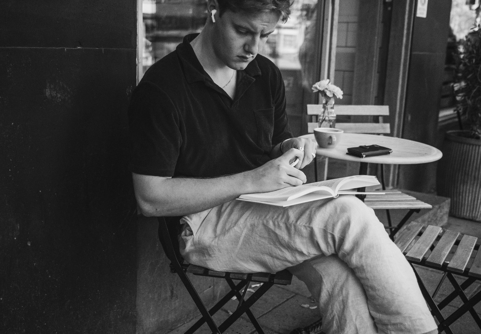 Man reading a book outside a cafe