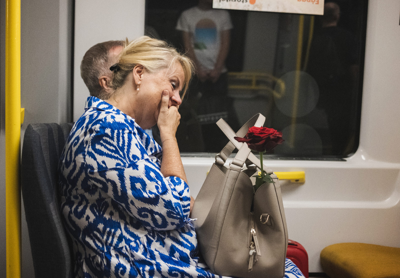 Laughing woman with rose in her handbag