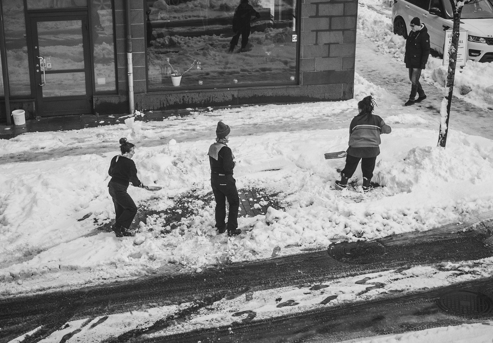 People shoveling snow from road