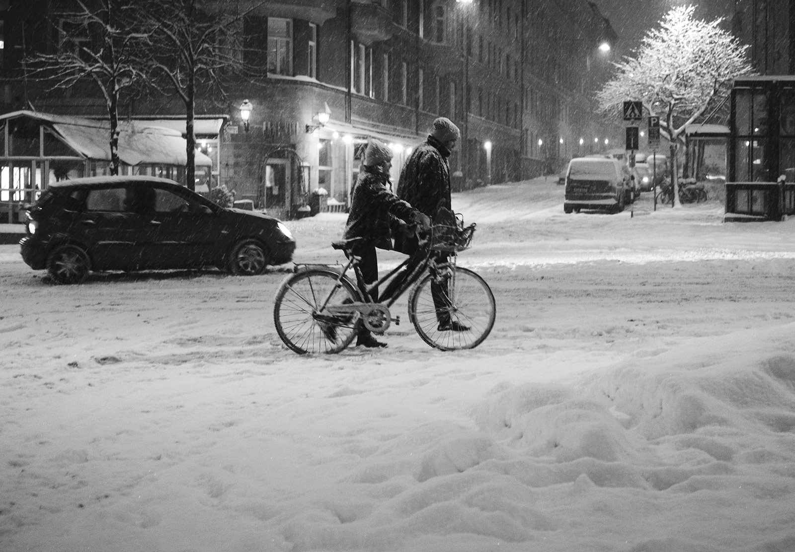 Woman pushing bike through snow