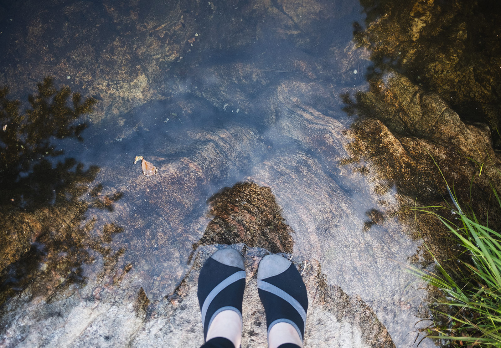 Feet standing at clear water