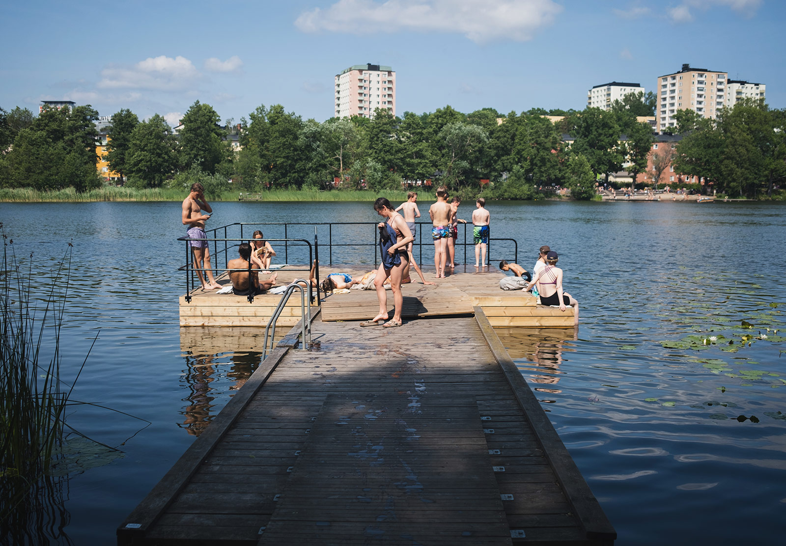 Swimmers standing on wooden jetty