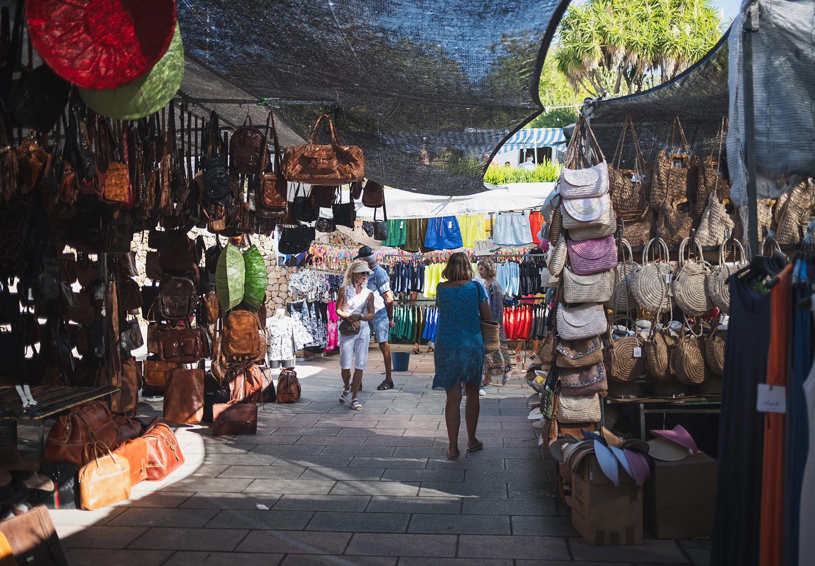 Handbags hanging on market stands